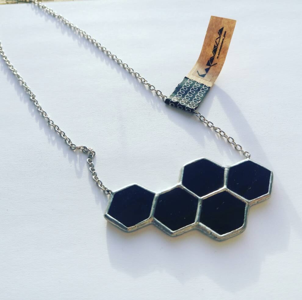 Geometric bee necklace photographed with sunflowers