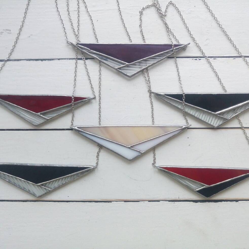 Color options (black, red, transparent) — a set of handmade geometric pendants.