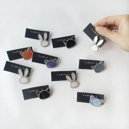 The photo shows cute stained glass brooches in the shape of a bear, a cat, a bunny, and a fox in different colors that you can choose as a gift for a jewelry lover, a student, a friend, or a child.