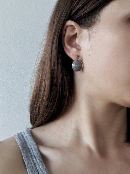 Grey stained glass stud earrings on model