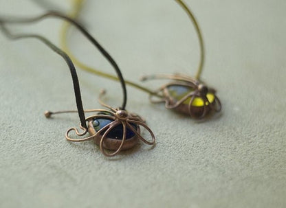 Glass butterfly necklaces on white background