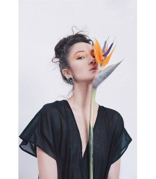 Black geometric earrings worn by model with stained glass disc and pyramid design