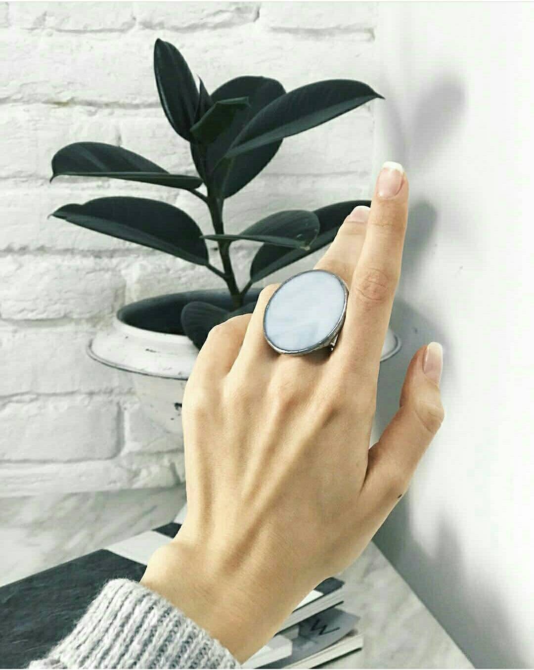 Light gray handmade stained glass ring with a large round disk in a geometric style on the model's hand. Вoho-minimalism decoration
