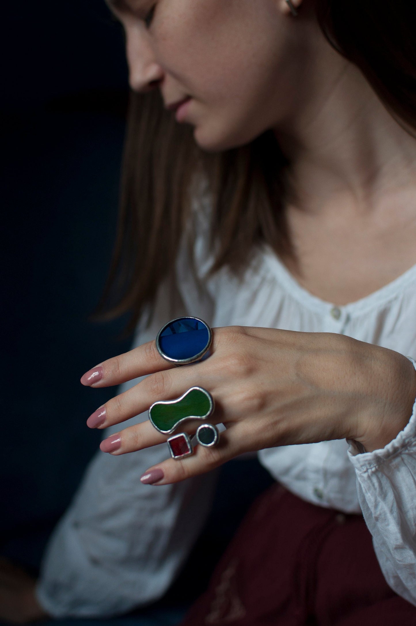 Handmade stained glass ring with red, green, and blue geometric elements on a hand — bold, colorful adjustable jewelry for women