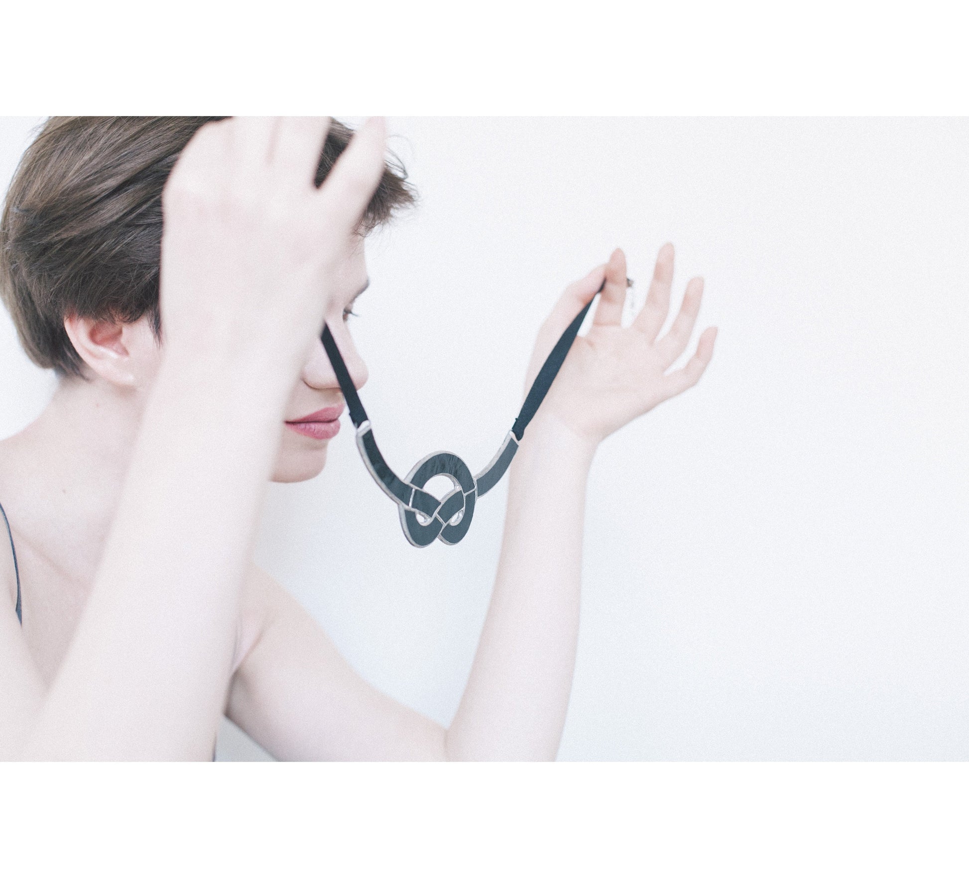 Woman holding twisted pendant – abstract art necklace