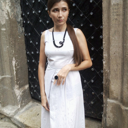 Model in white dress wearing black chevron necklace