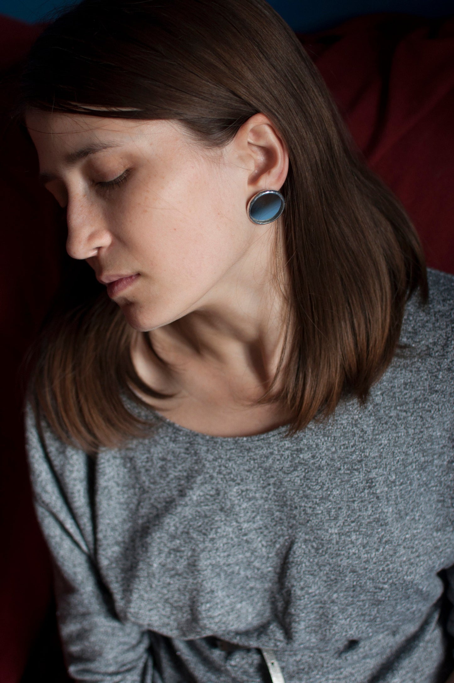 Mirror round earrings, on the ear of a young woman
