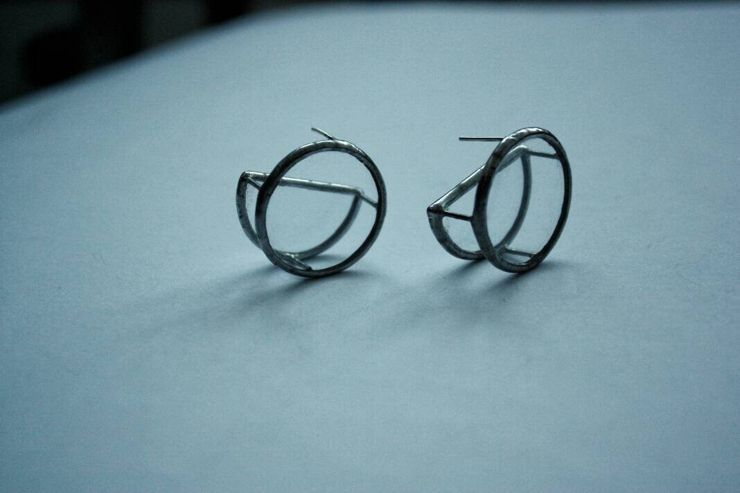 Close-up of transparent double disc earrings on white background