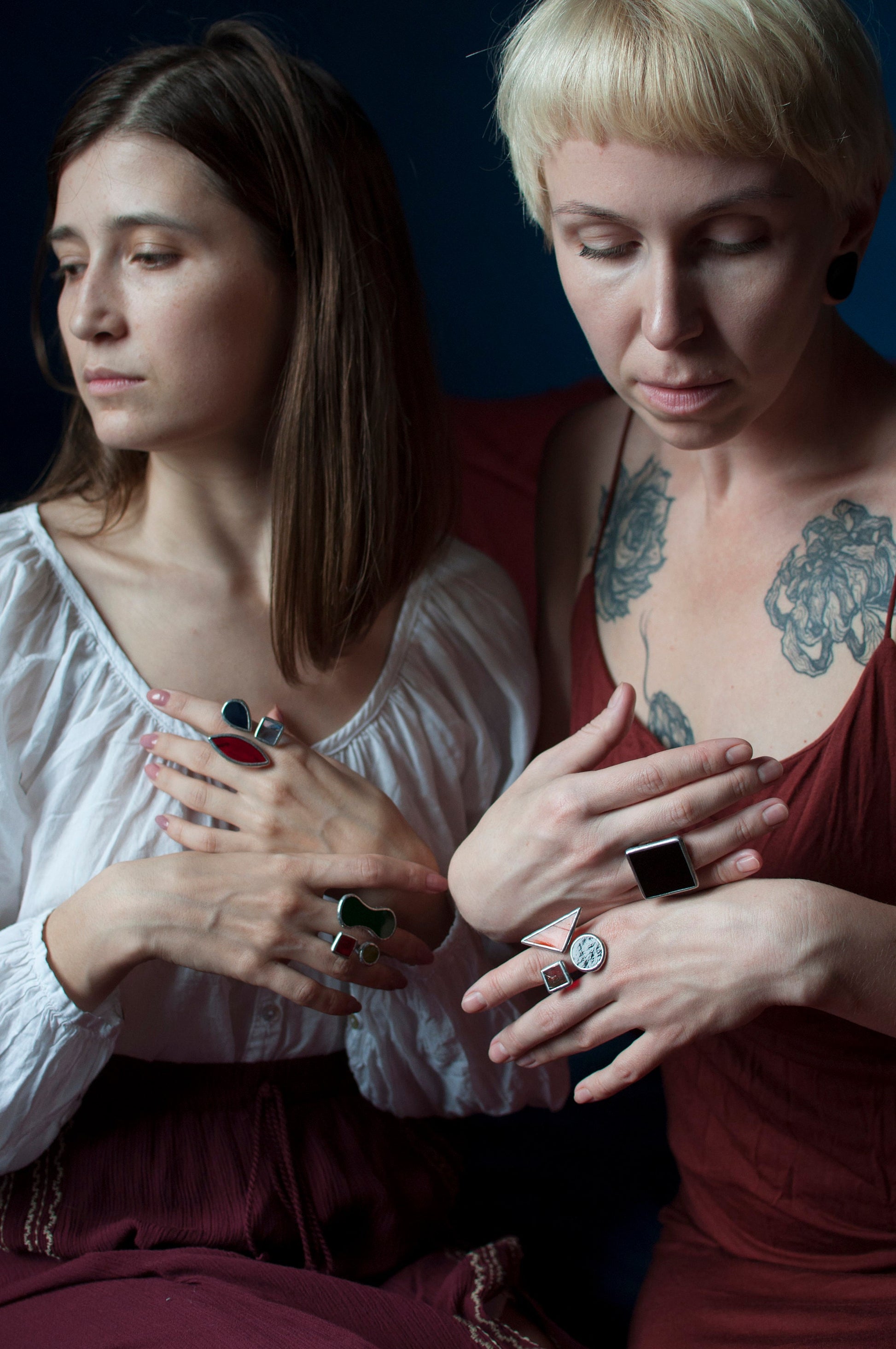 Multiple stained glass rings with bold colors on women's hands — artistic handmade jewelry with modern design