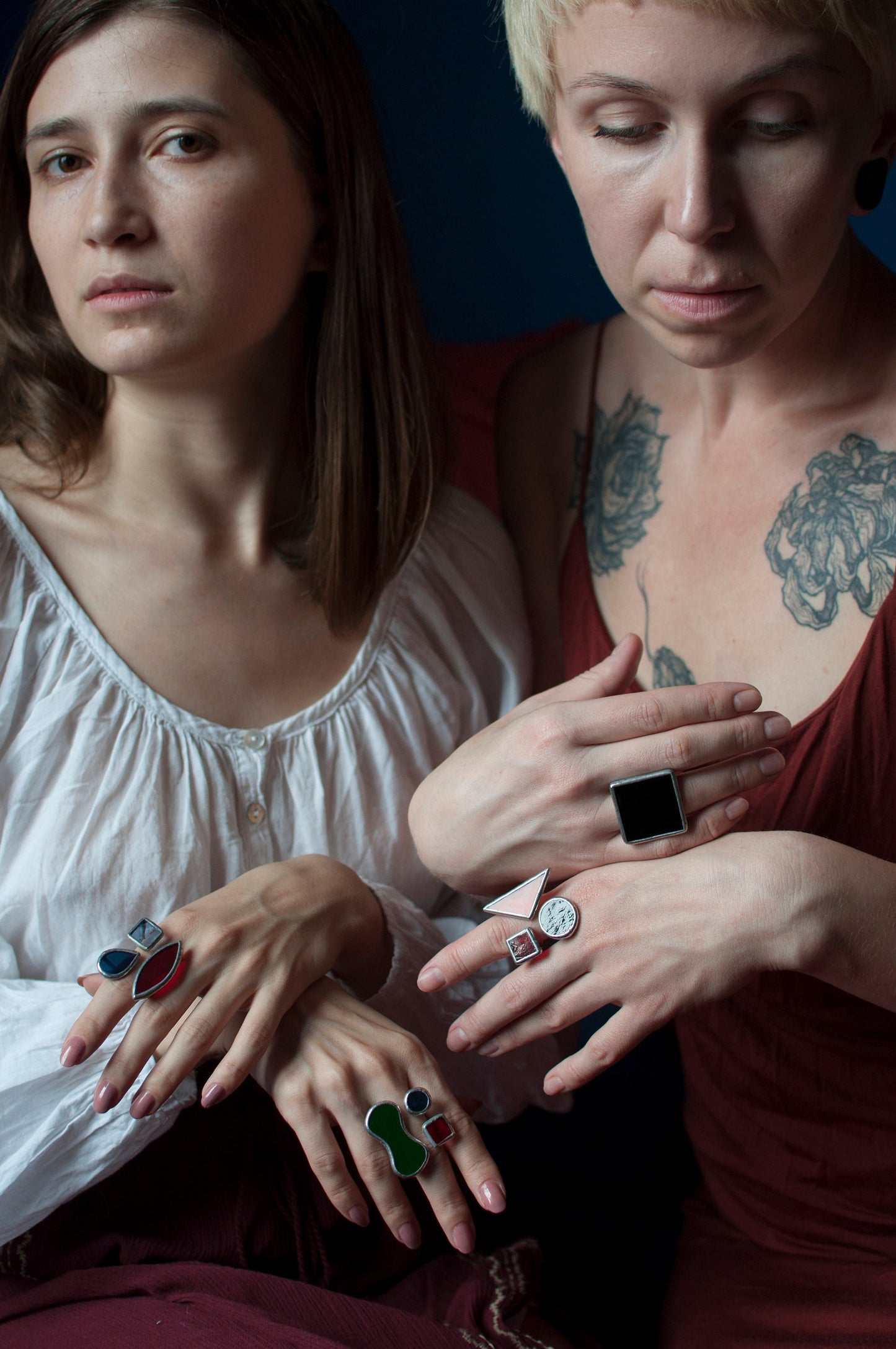 Multiple stained glass rings with bold colors on women's hands — artistic handmade jewelry with modern design