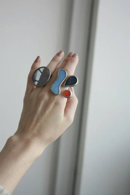 Abstract stained glass ring with blue, red, and black shapes