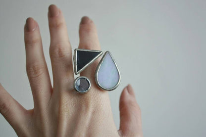 Blue stained glass geometric ring with teardrop, circle and triangle on hand