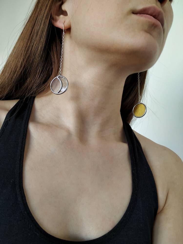 Asymmetric sun and moon phase stained glass earrings on model