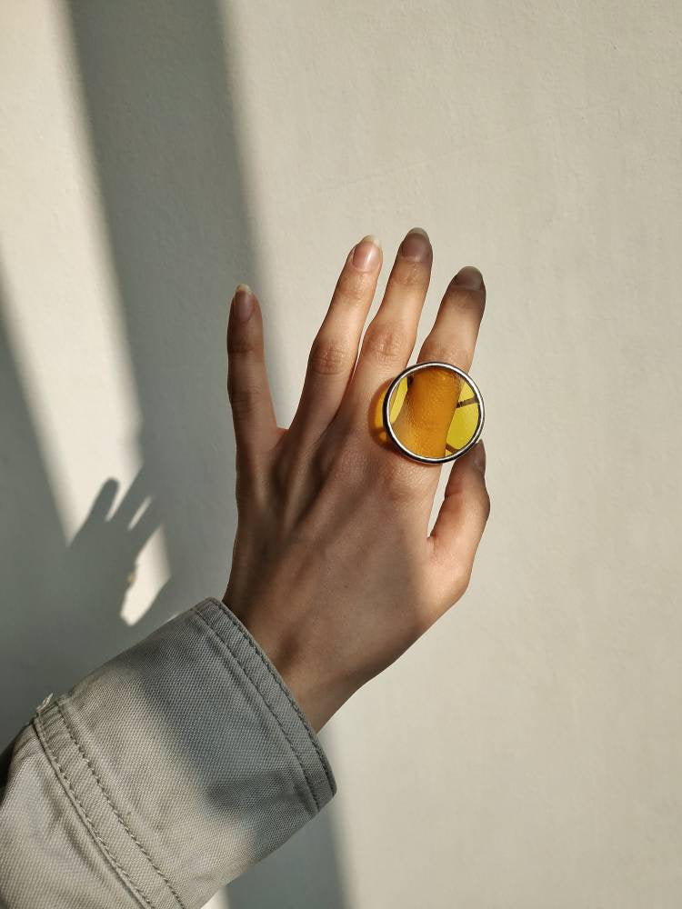 Handmade yellow glass statement ring worn on finger