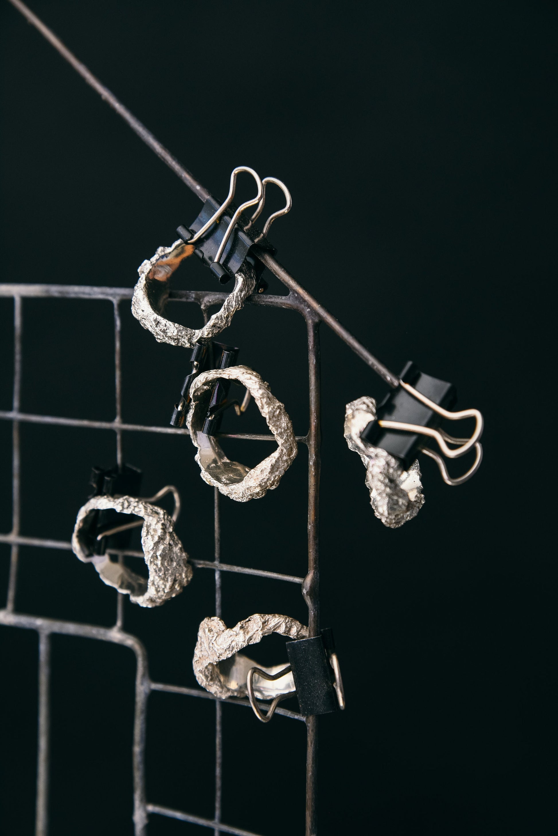 Silver crumpled ring detail on dark background