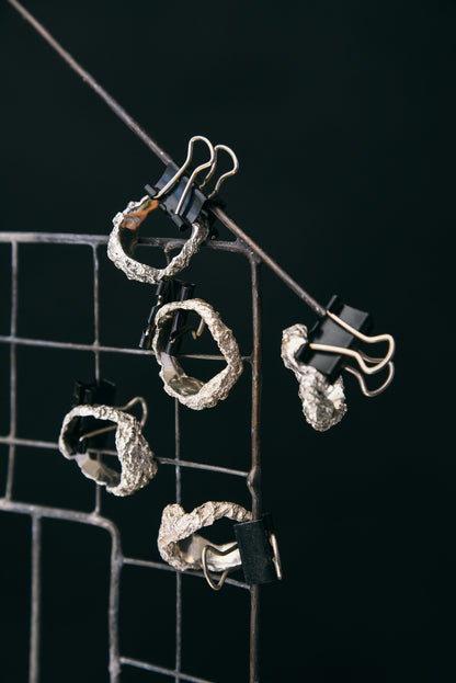Silver crumpled ring detail on dark background