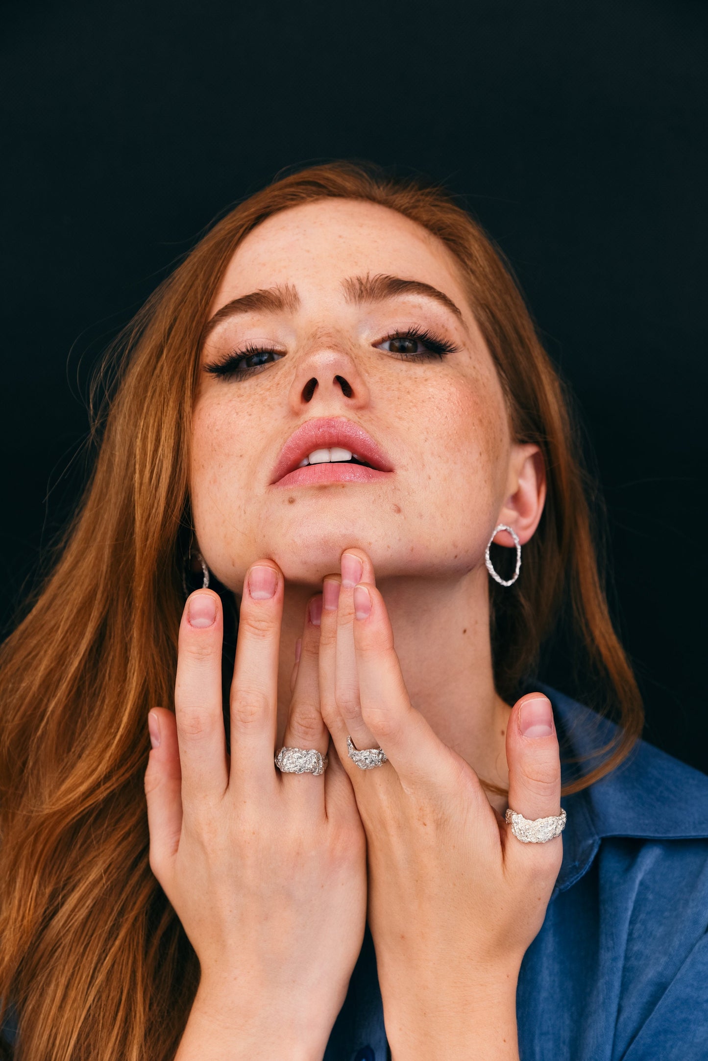 Hands wearing chunky textured rings in natural light