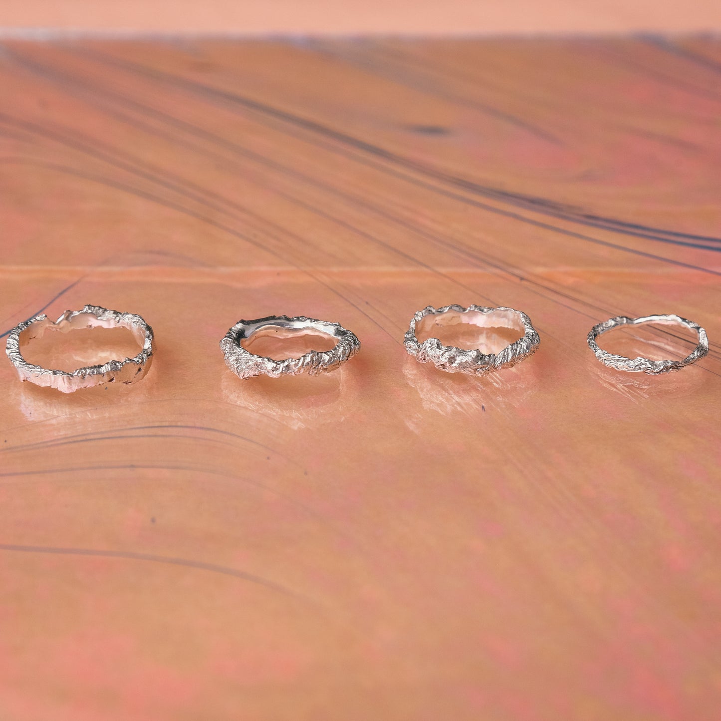 Minimalist sterling silver hammered rings on pastel background