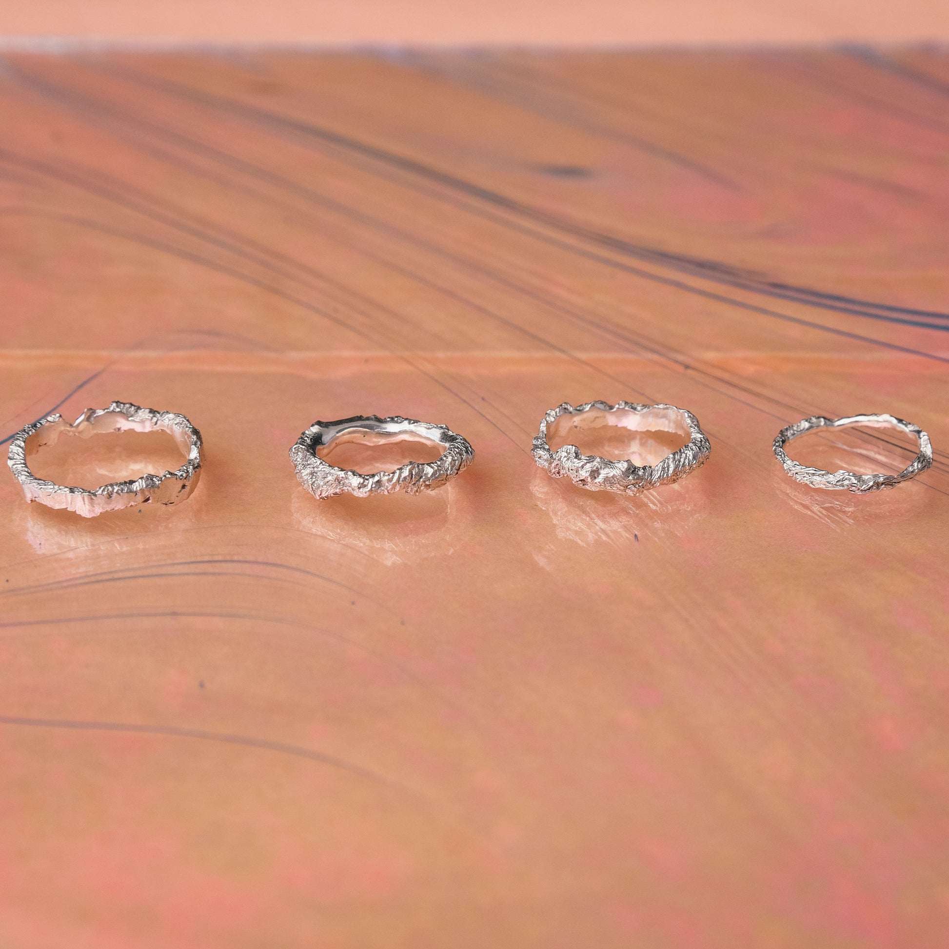 Minimalist sterling silver hammered rings on pastel background