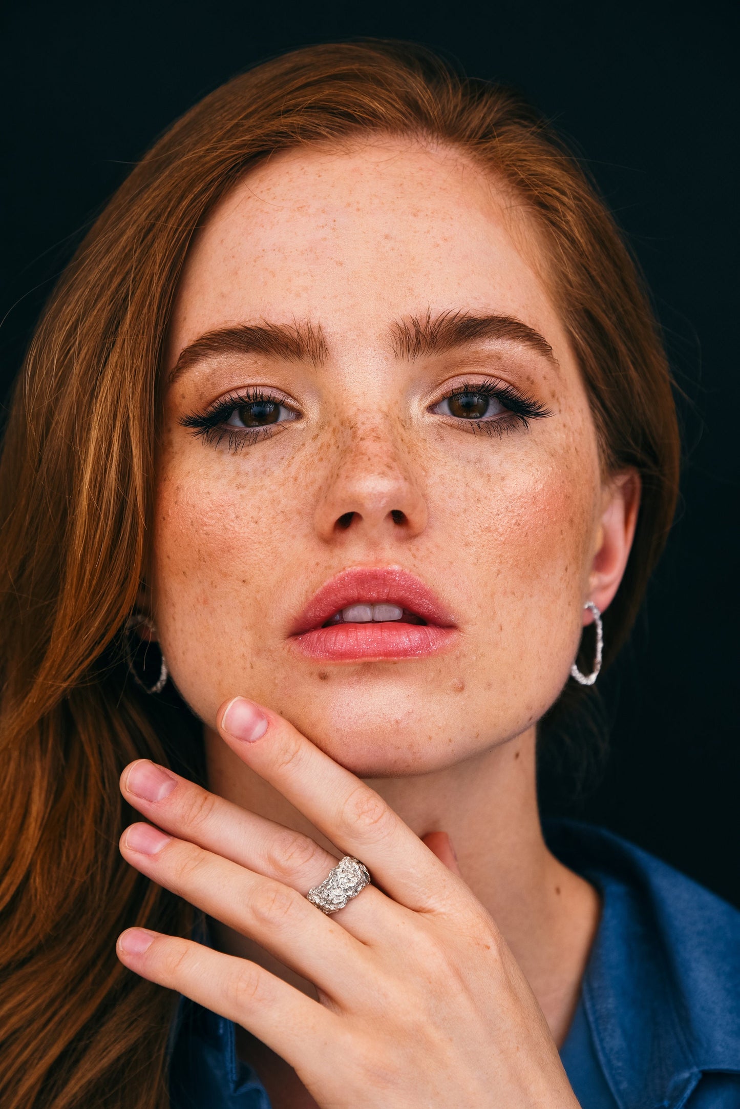 Modern statement silver ring worn on model’s hand, bold dome design