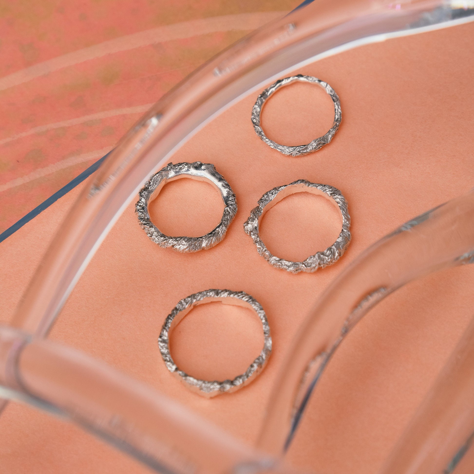 Stylish hammered ring close-up next to clear glass.