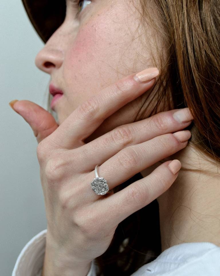 Geometric sterling silver ring worn on finger, minimalist style