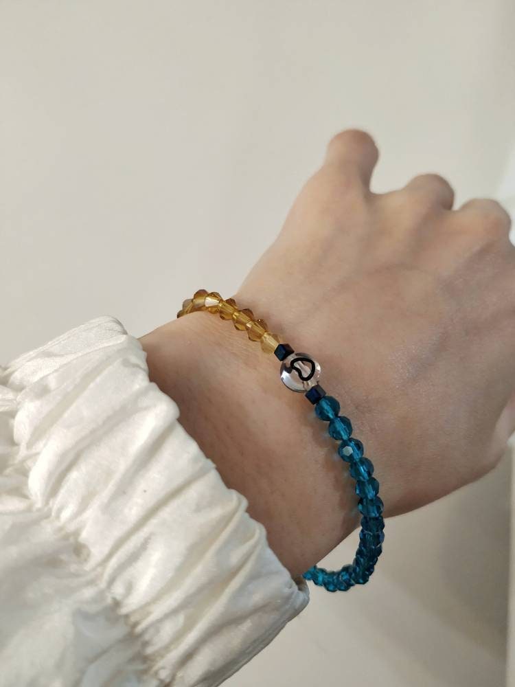 Handmade blue yellow heart bead bracelet worn on hand
