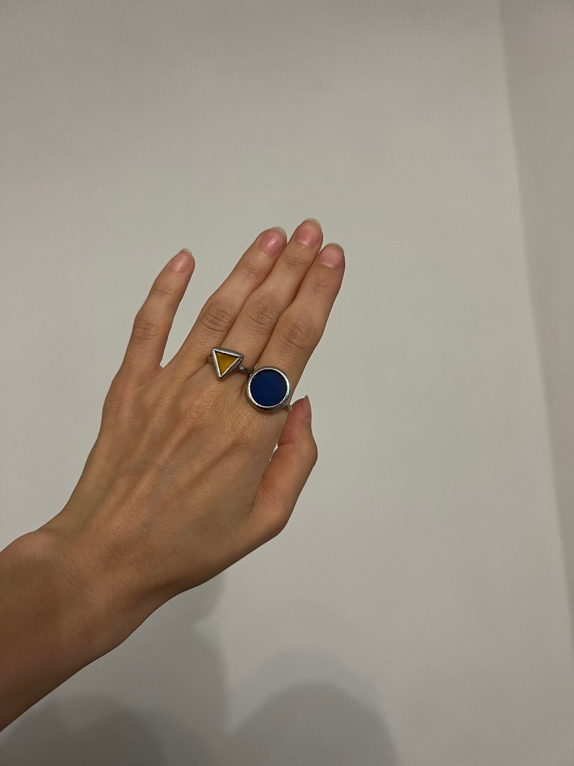 A set of modern handmade stained glass rings in the shape of small triangles and round discs in rich shades of deep blue and bright yellow. Geometric rings are created using the stained glass technique with a unique design - they combine minimalism and expressiveness, suitable as a statement ring set or a delicate gift for a mother, friend or lover. These elegant jewelry will harmoniously complement a modern look, become a symbol of care and style, as well as an ideal accessory