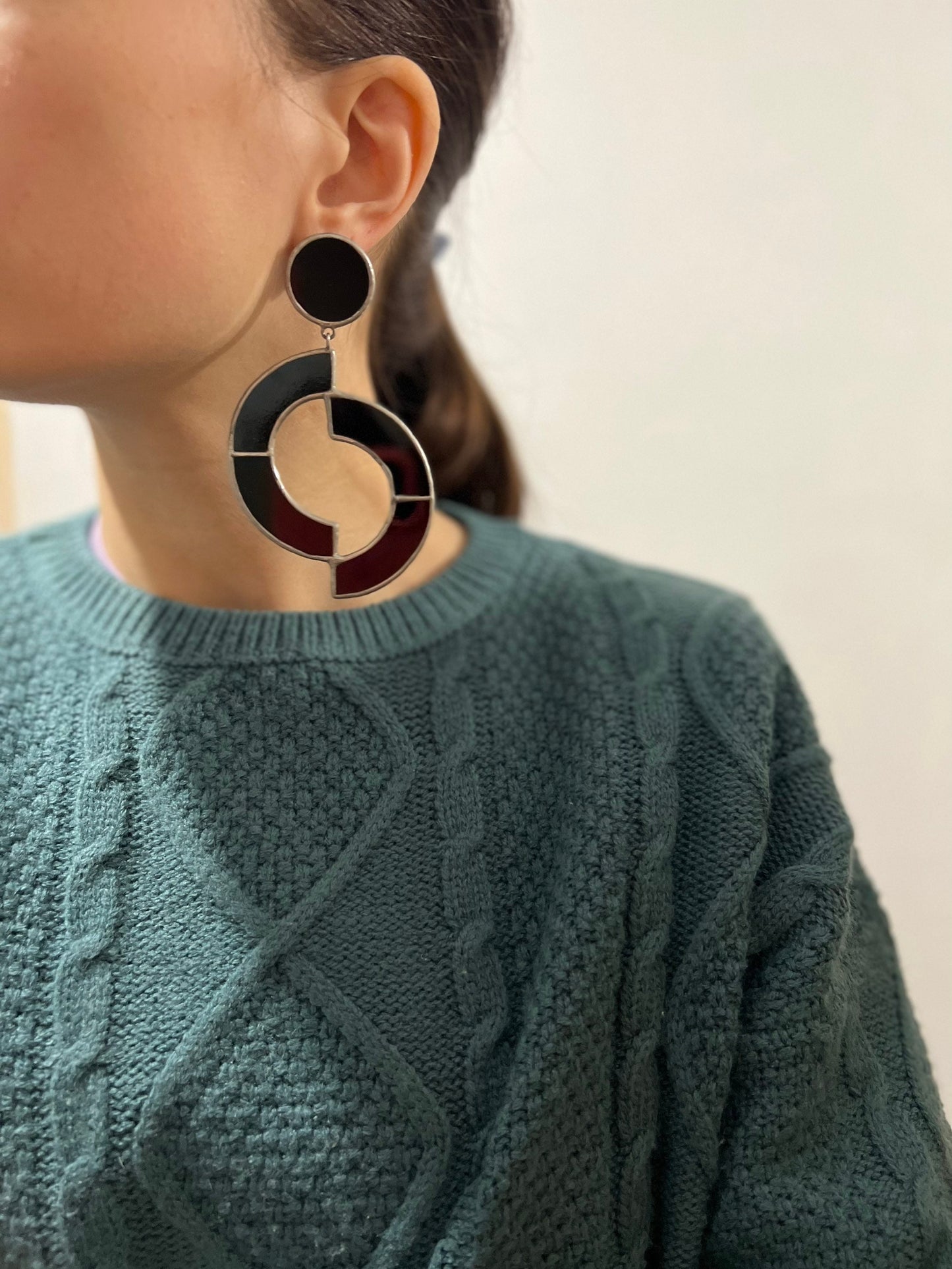 Model wearing black geometric stained glass earrings