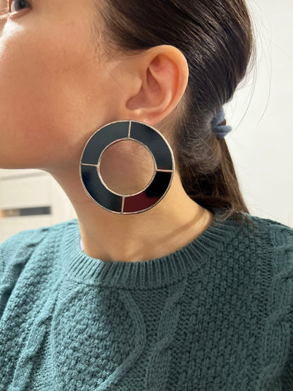 Black circle stained glass earrings with modern pattern on ear