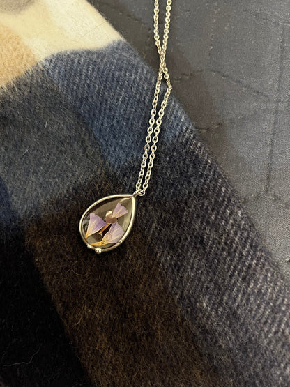 Purple dried flower glass necklace photographed on sweater texture
