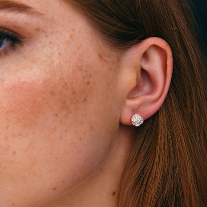 Model wearing modern sculptural earrings in silver.