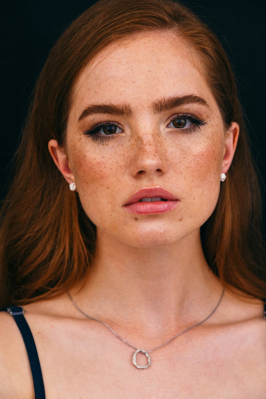 Model wearing handmade silver stud earrings, minimalist crumpled design