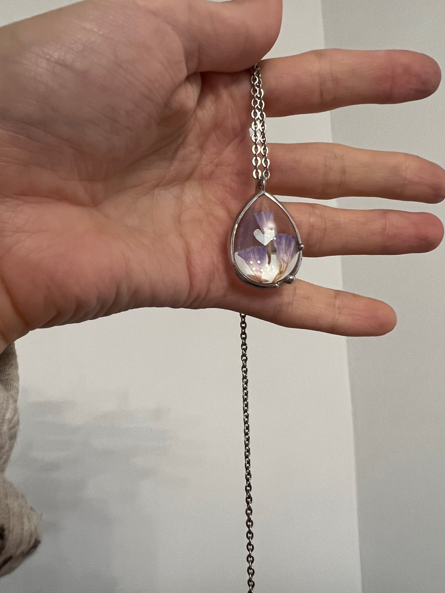 Close view of purple dried flower pendant in stained glass frame