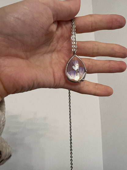 Close view of purple dried flower pendant in stained glass frame