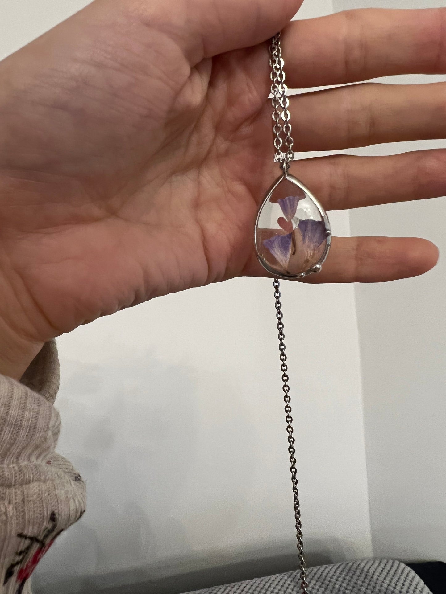 Teardrop flower necklace shown in hand for size reference
