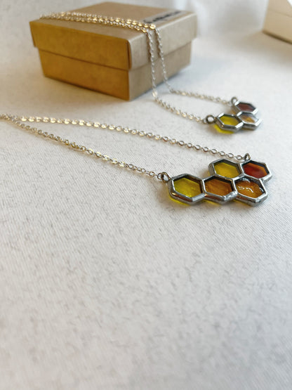 Handmade stained glass bee inspired honeycomb necklace close up