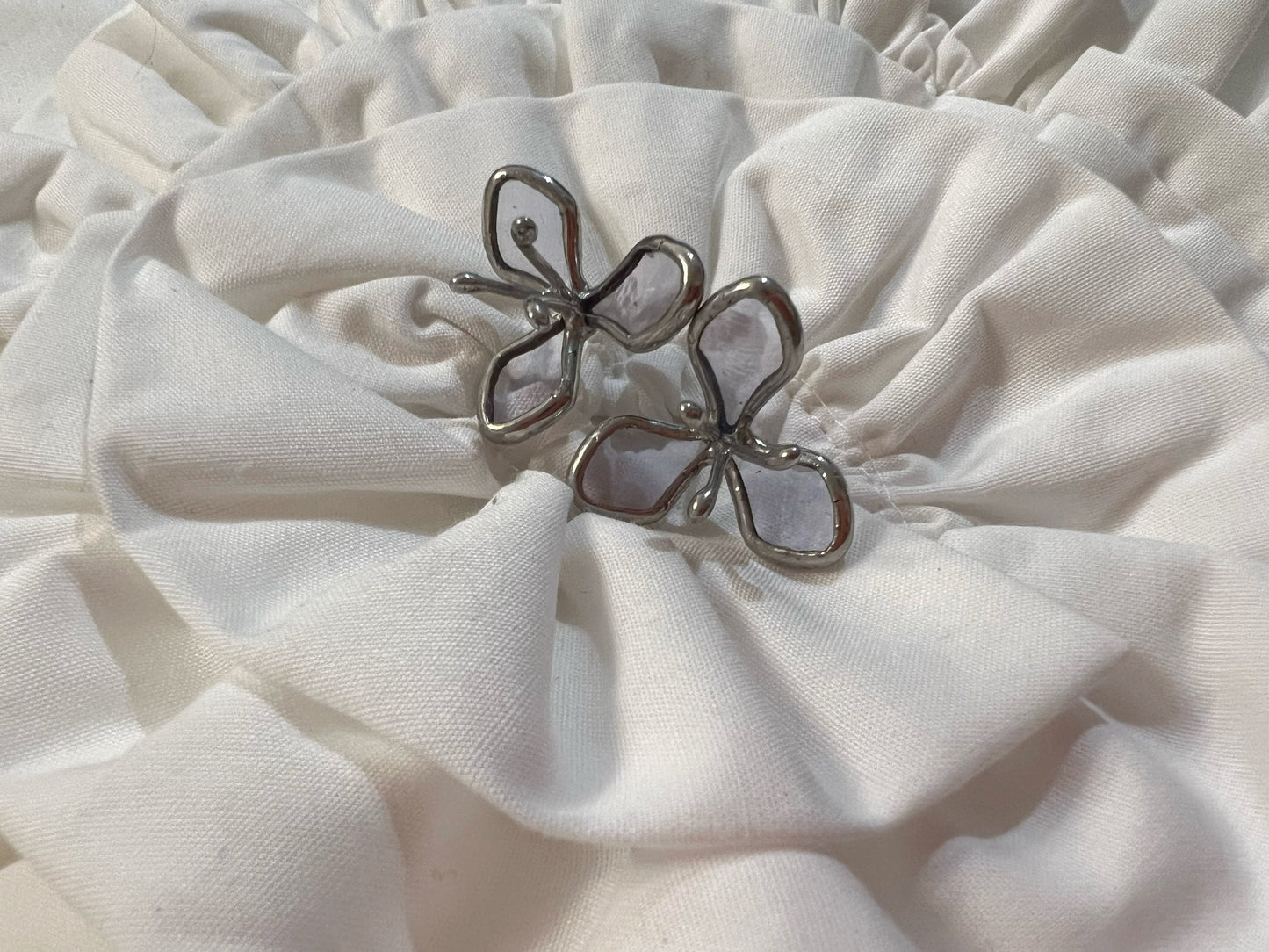 Light purple stained glass flower earrings on white cloth