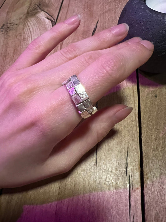 Textured silver ring on wooden surface – handmade pavement-inspired jewelry
