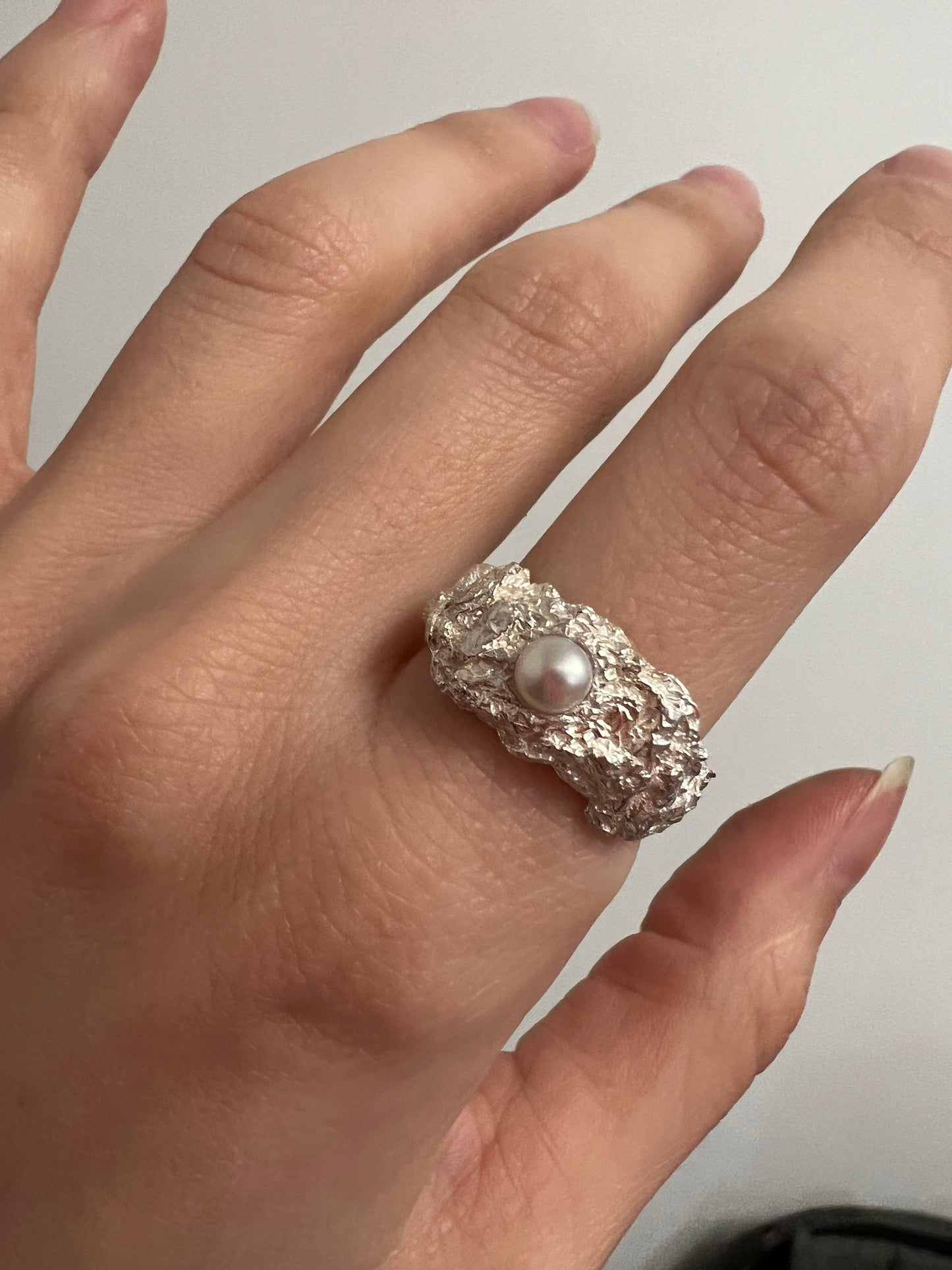 Textured silver pearl ring worn as statement jewelry