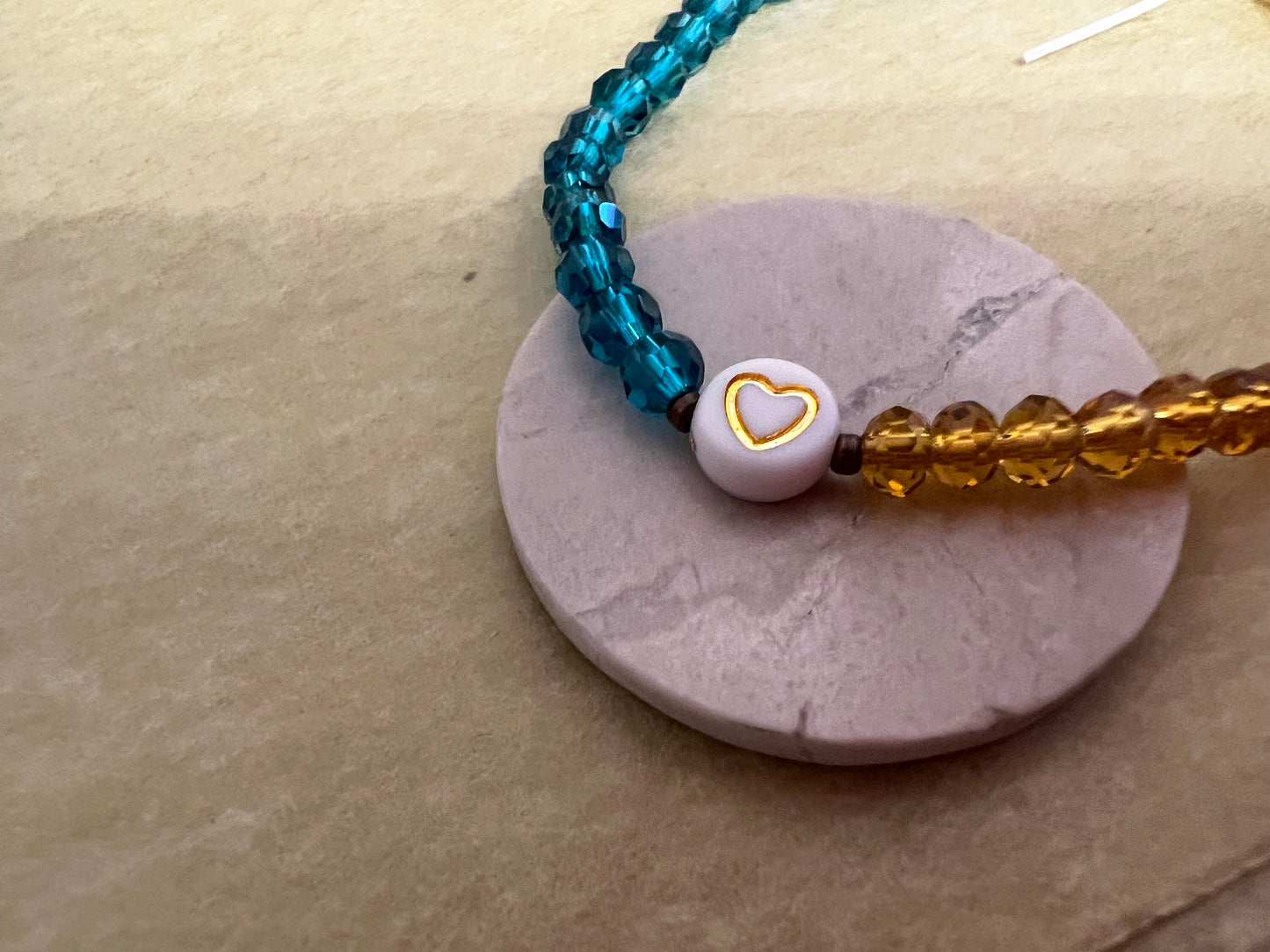 Blue yellow bracelet styled on ceramic stand