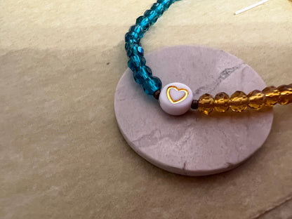 Blue yellow bracelet styled on ceramic stand