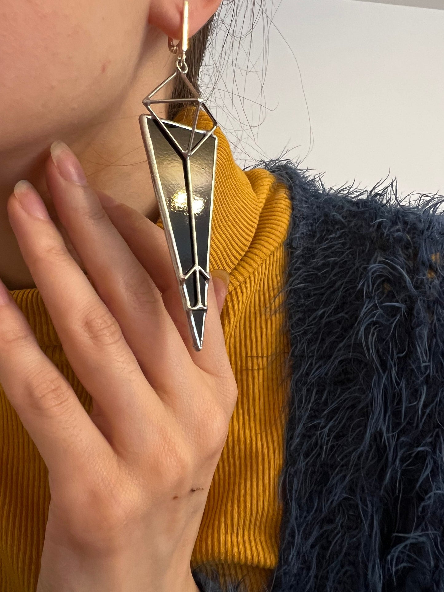 Black architectural earrings paired with matching statement ring