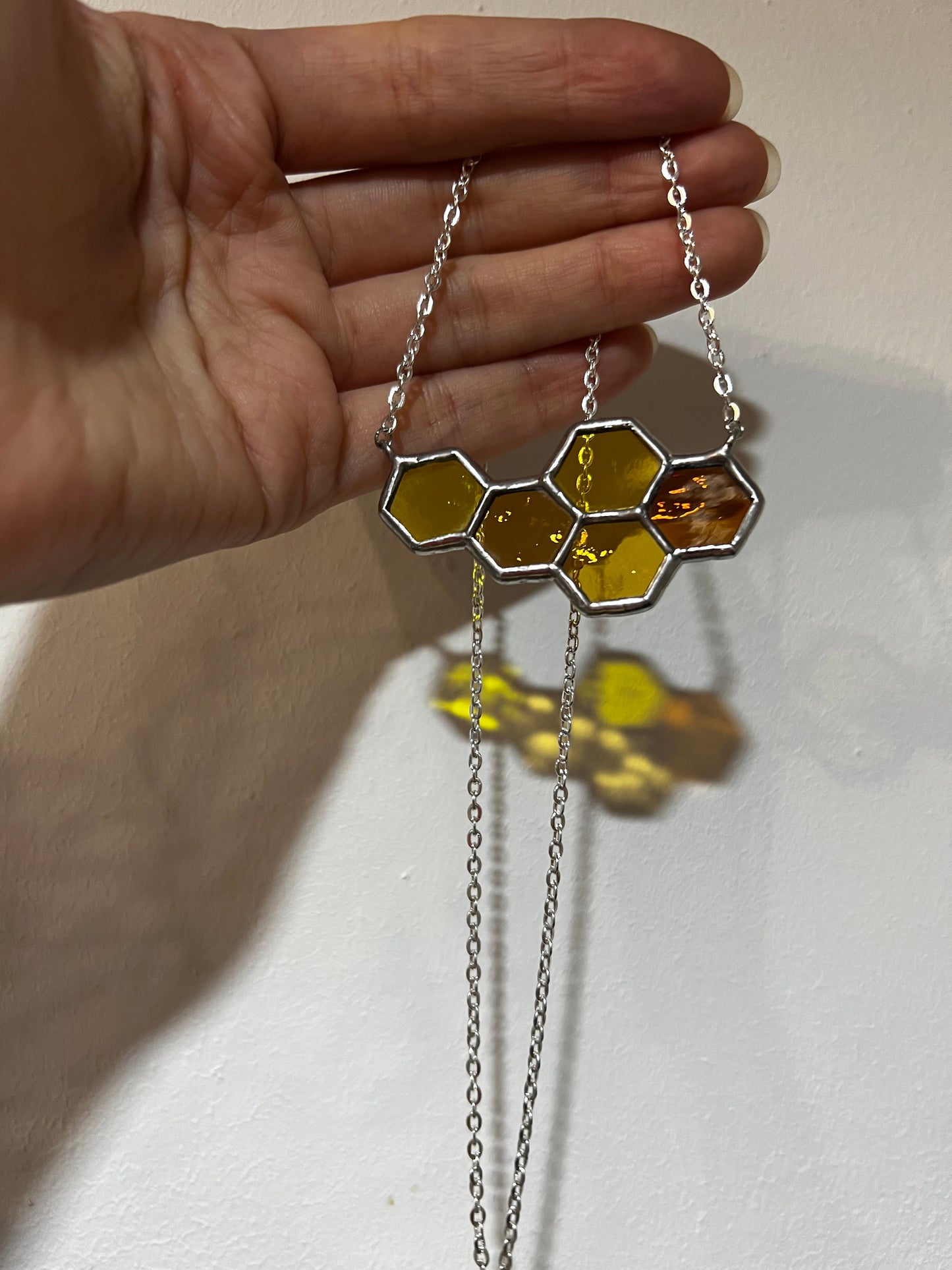 Bee inspired honeycomb necklace glowing in sunlight