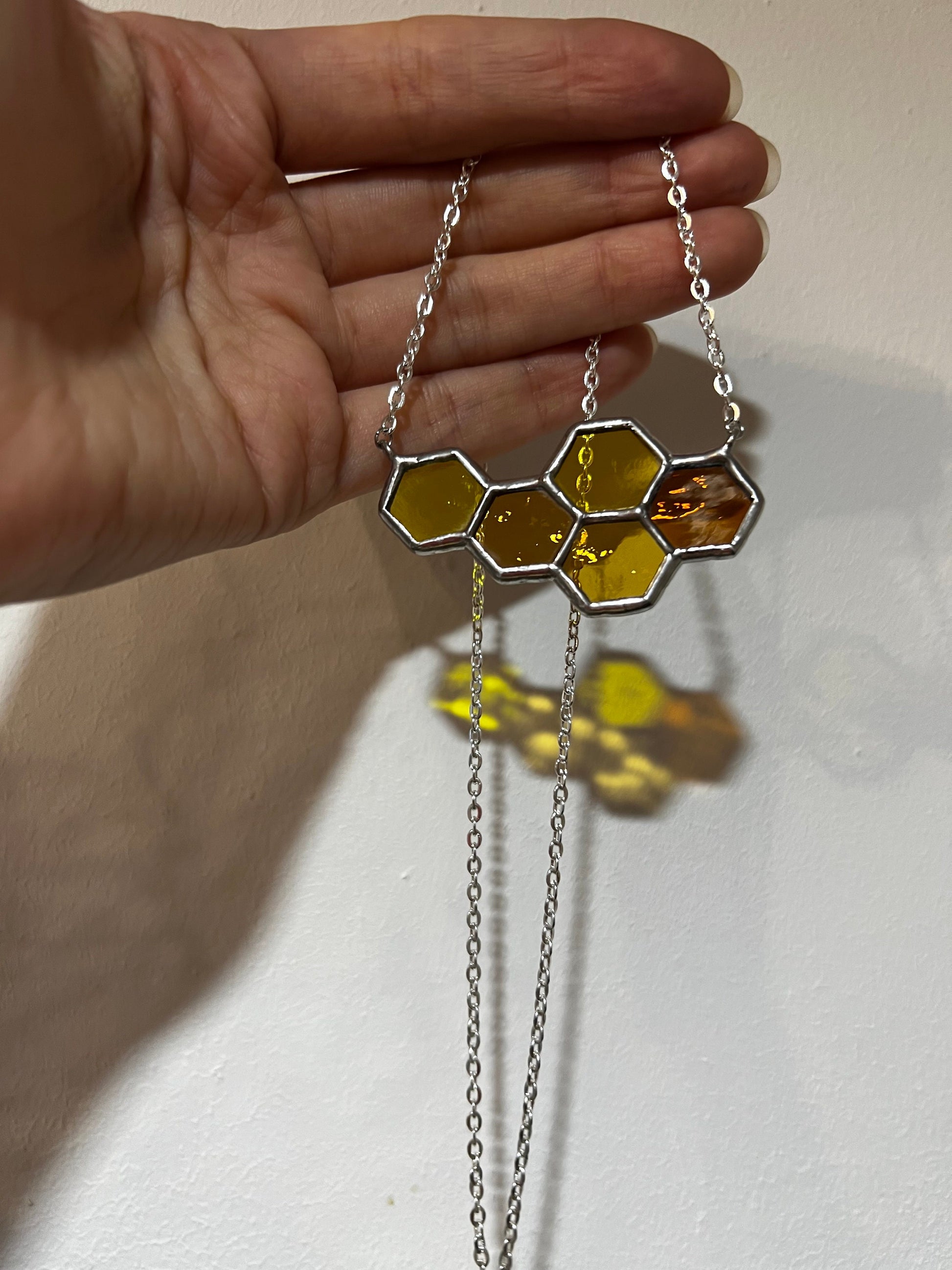 Bee inspired honeycomb necklace glowing in sunlight