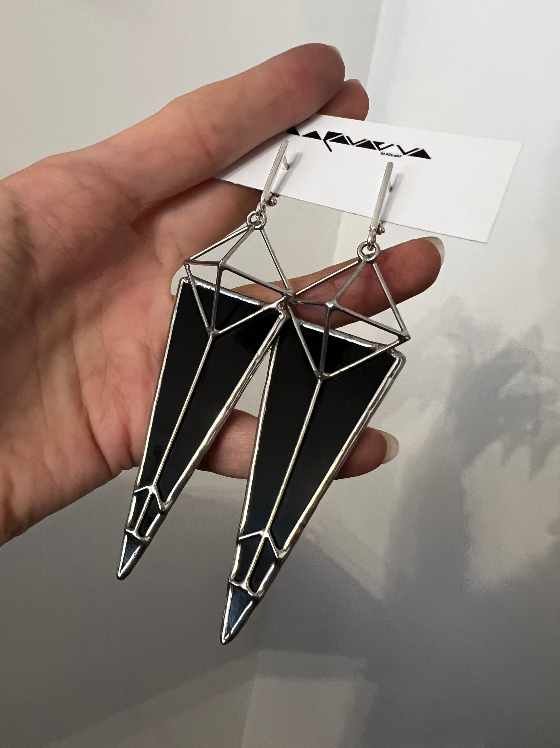 Hand holding black stained glass earrings, handmade artisan details