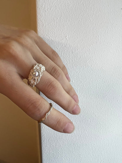 Model holding handmade oxidized ring with pearl, artistic fashion tone