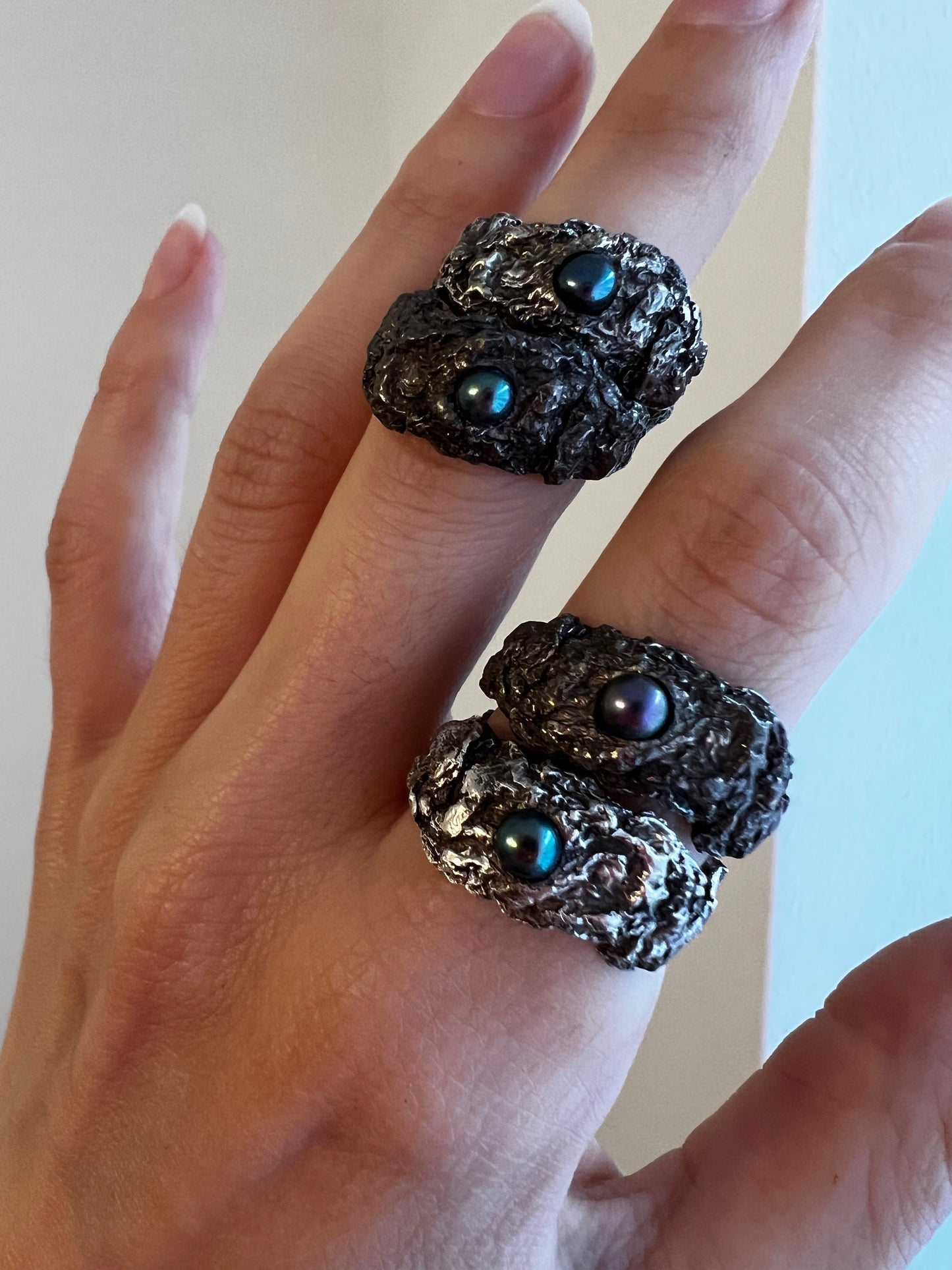 Dark oxidized silver rings with black and blue pearls, artistic handmade statement jewelry.