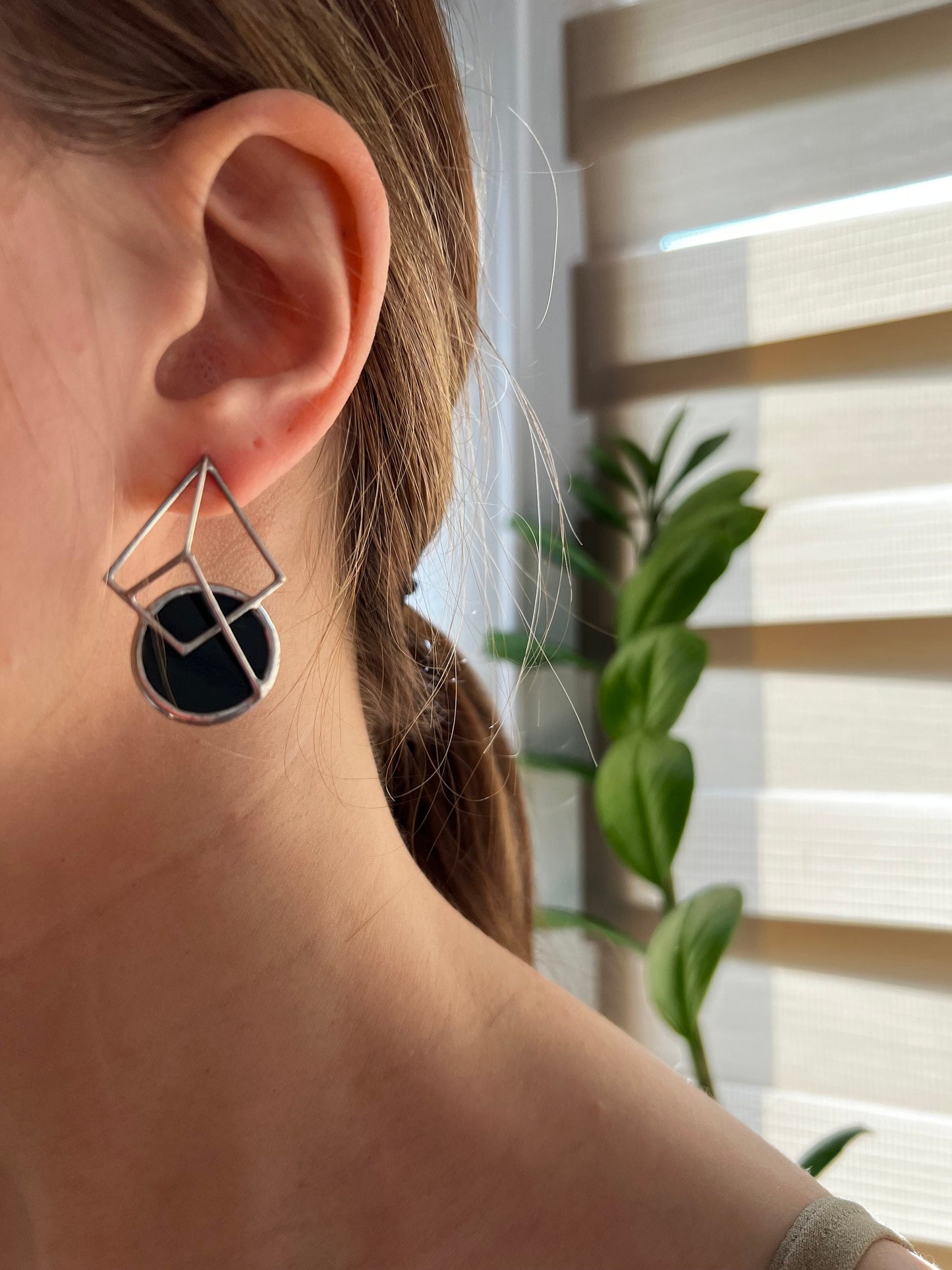 Black geometric earrings close-up in natural light