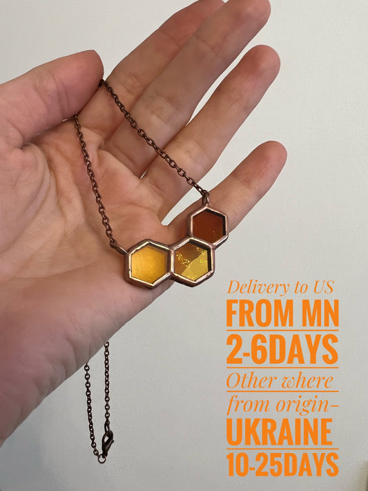 Stained glass honeycomb necklace in yellow shades on hand